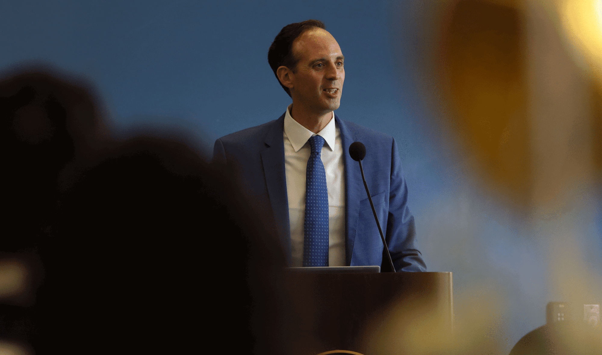 Chancellor in a blue suit at a podium
