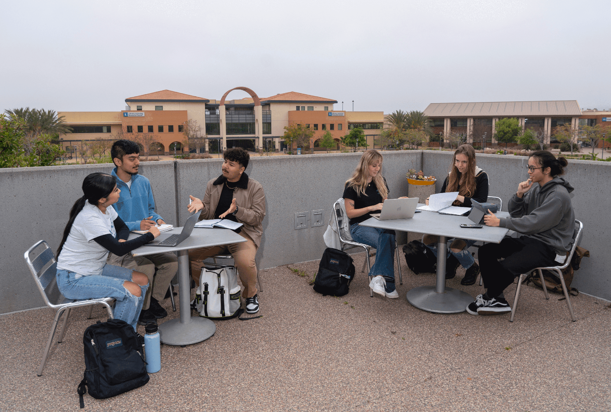 Students sit at tables on a rooftop at Miramar College
