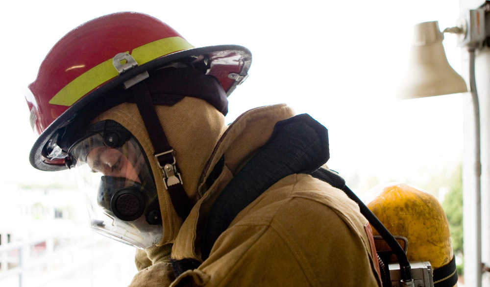 Firefighter wears a helmet and mask