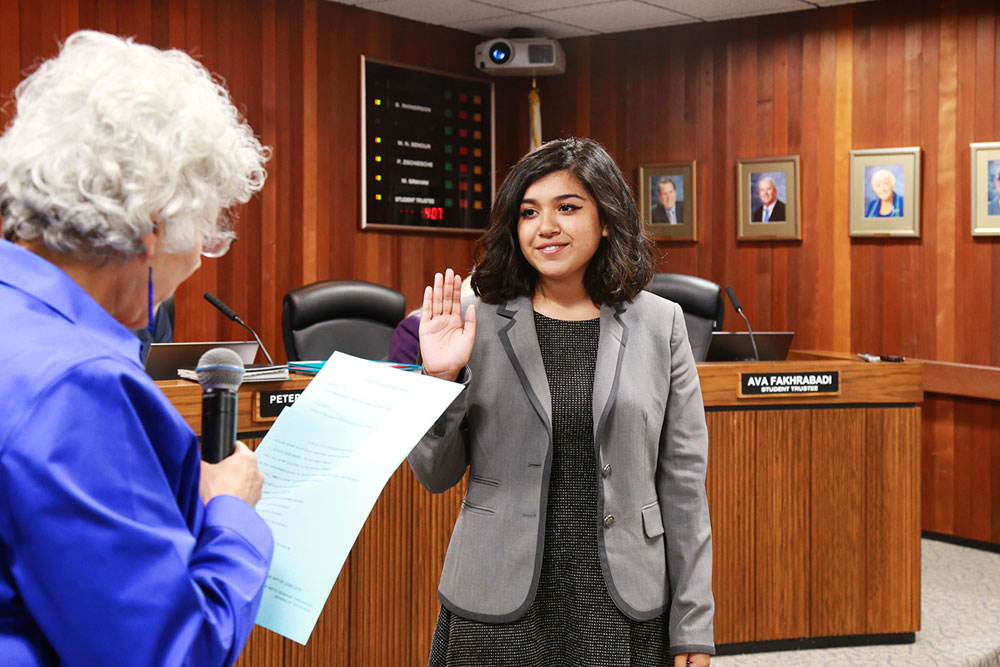 a student is sworn in as a student trustee at a board meeting