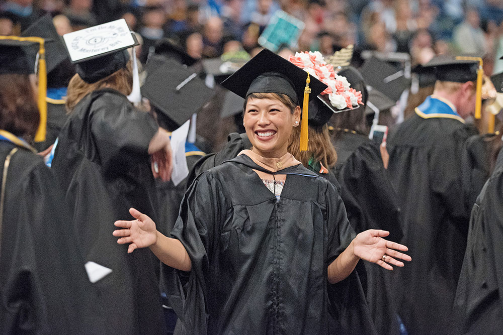 Mesa College employee in a cap and gown at graduation.