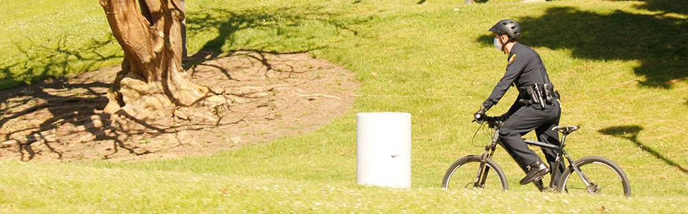 A College Police officer rides a bike through the San Diego City College campus.