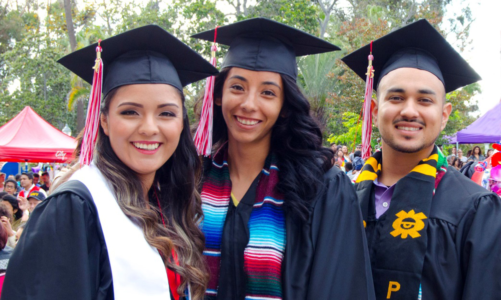 Three students pose in their caps and gowns at the City College 2016 commencement ceremony.
