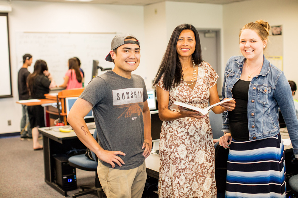 Dr. Carmen Carrasquillo Jay with two students in a classroom