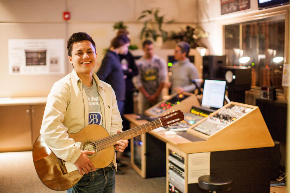 A Mesa College music student holds a guitar