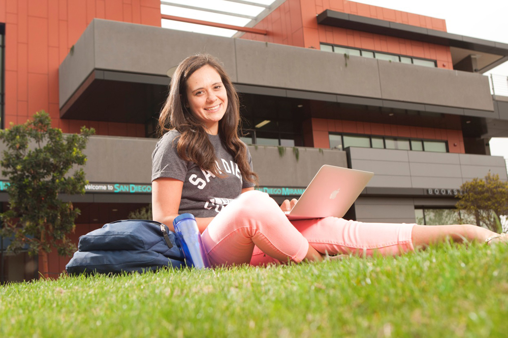 a female student sits on the lawn at miramar college