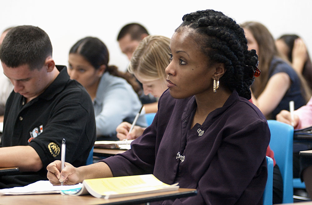 A student takes notes in a classroom.