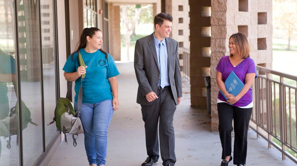 President Carlos O. Turner Cortez walks with two students at Continuing Education