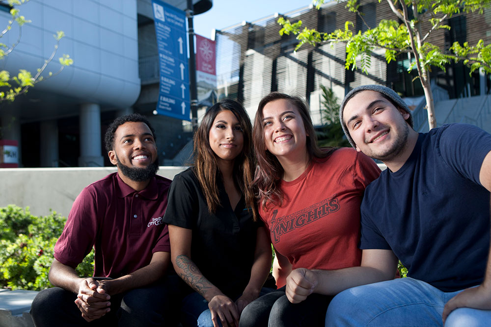 Four students sit outside at City College