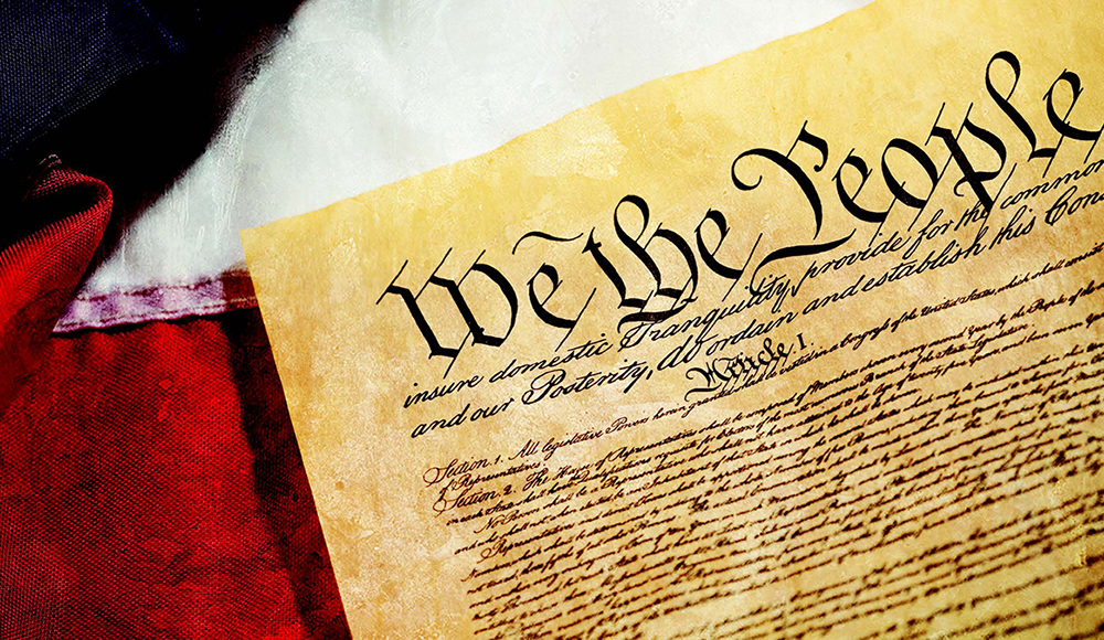 A copy of the Constitution lays on an American Flag