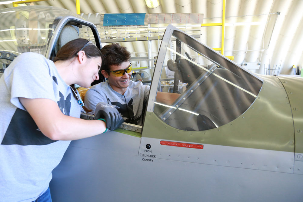 Miramar College aviation maintenance technology students Genevieve Cindrich and Derrick Caceres assist with restoration of a P-51 Mustang.