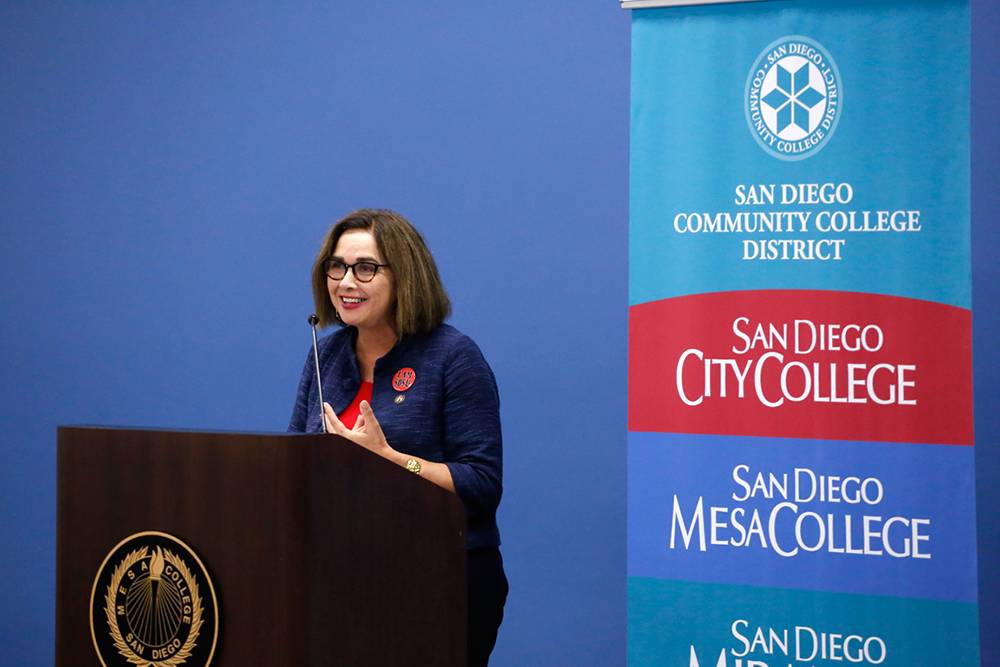 Adela de la Torres speaks at a dais