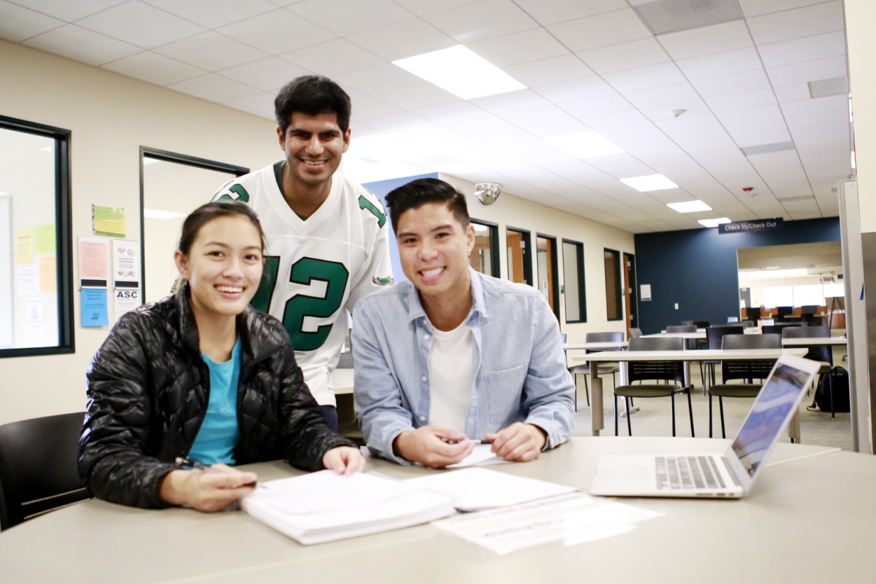 Three students at a table with a computer