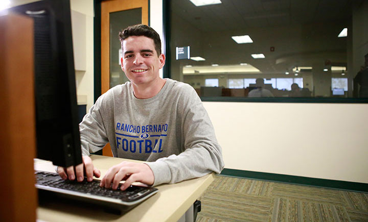 Matthew Quis sits at a computer at Miramar College