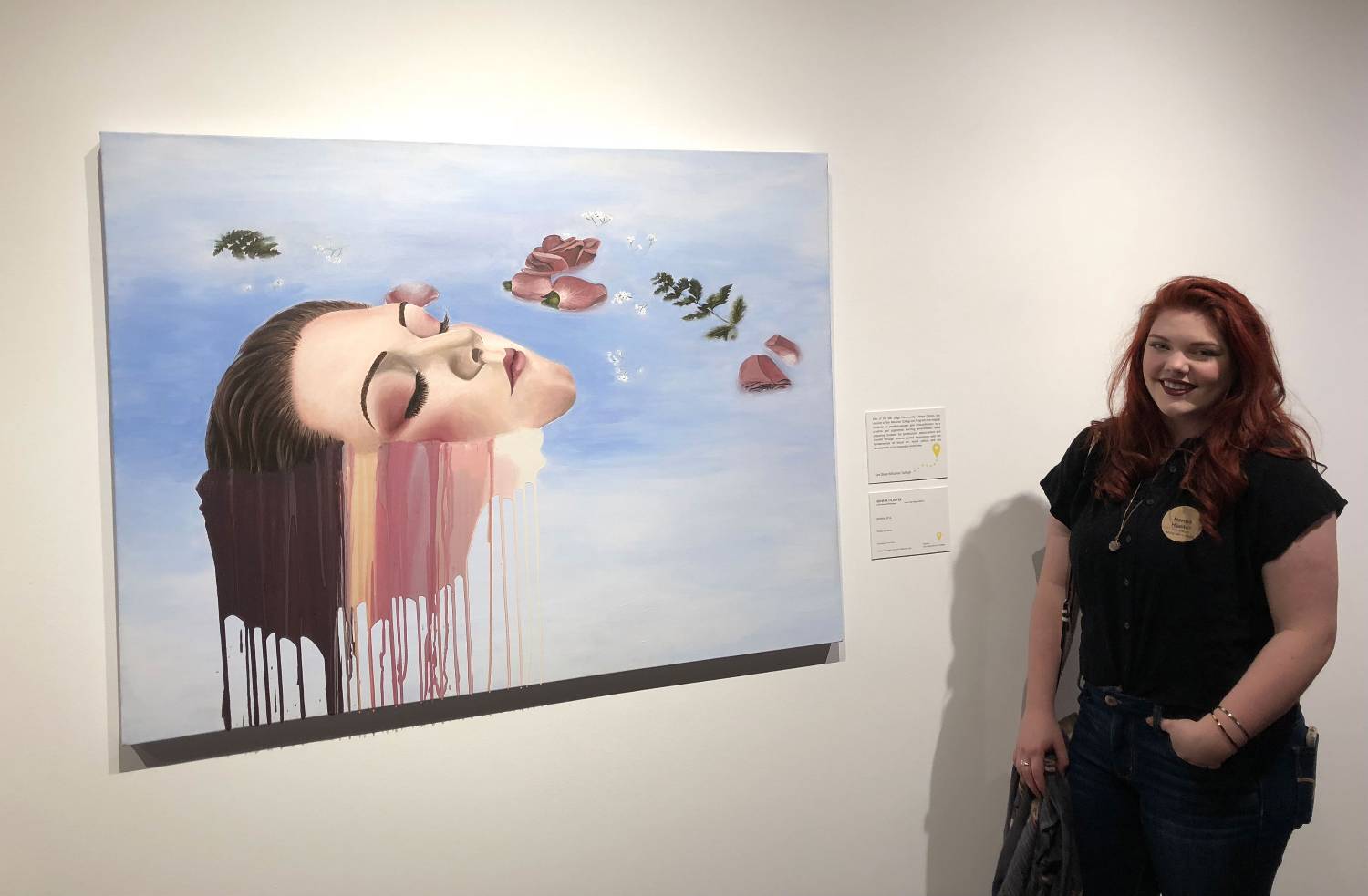 Hanna Hunter stands next to one of her paintings