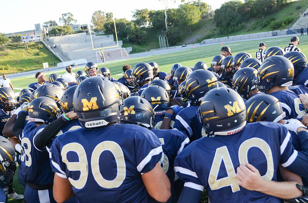 Mesa college football players in a huddle