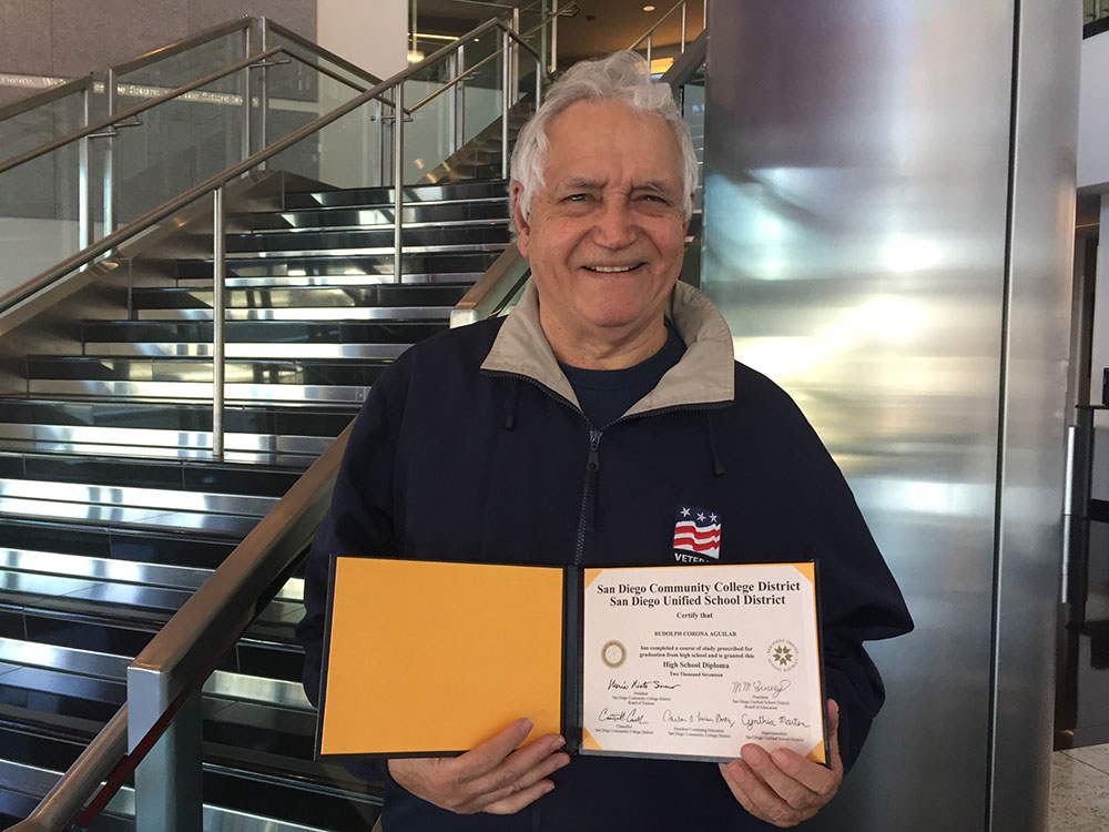 Rudy Aguilar holds his high school diploma