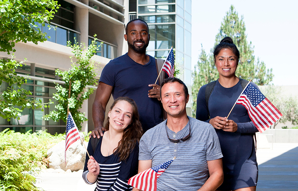 4 student veterans holding small American flags