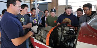 A group of students look at an engine