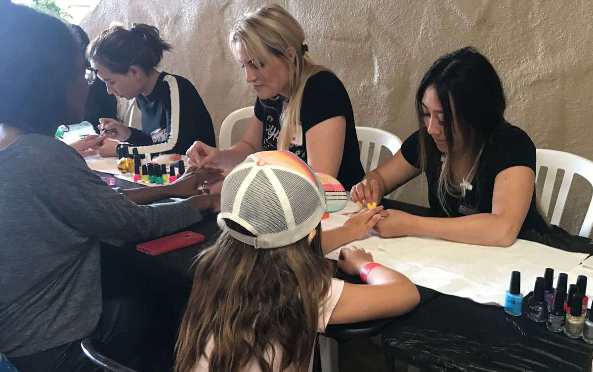 A fairgoer gets her nails done at the fair