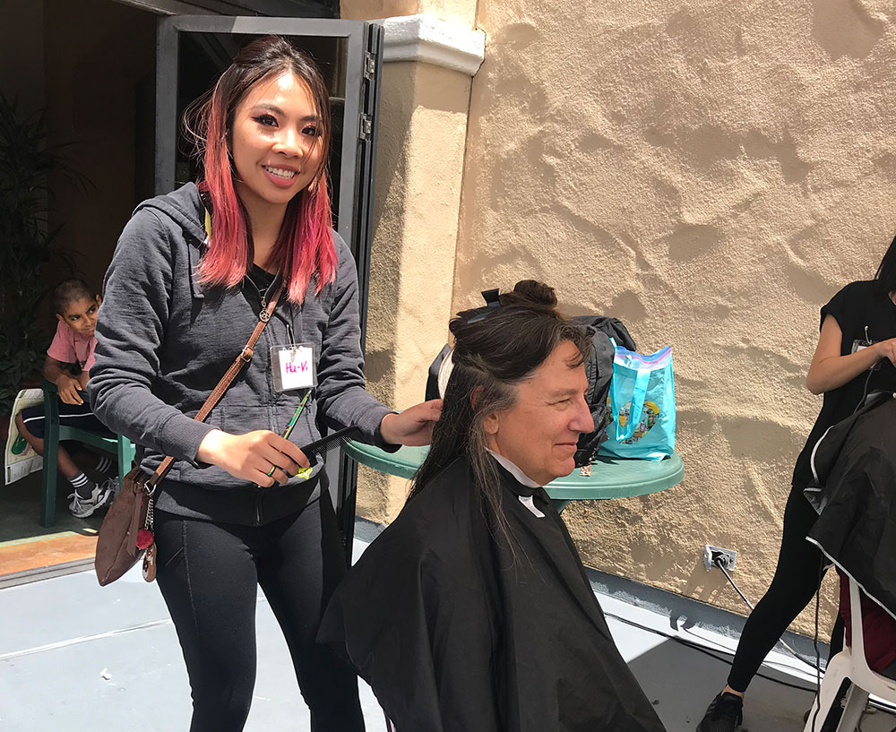 A cosmetology student gives a free haircut at the fair