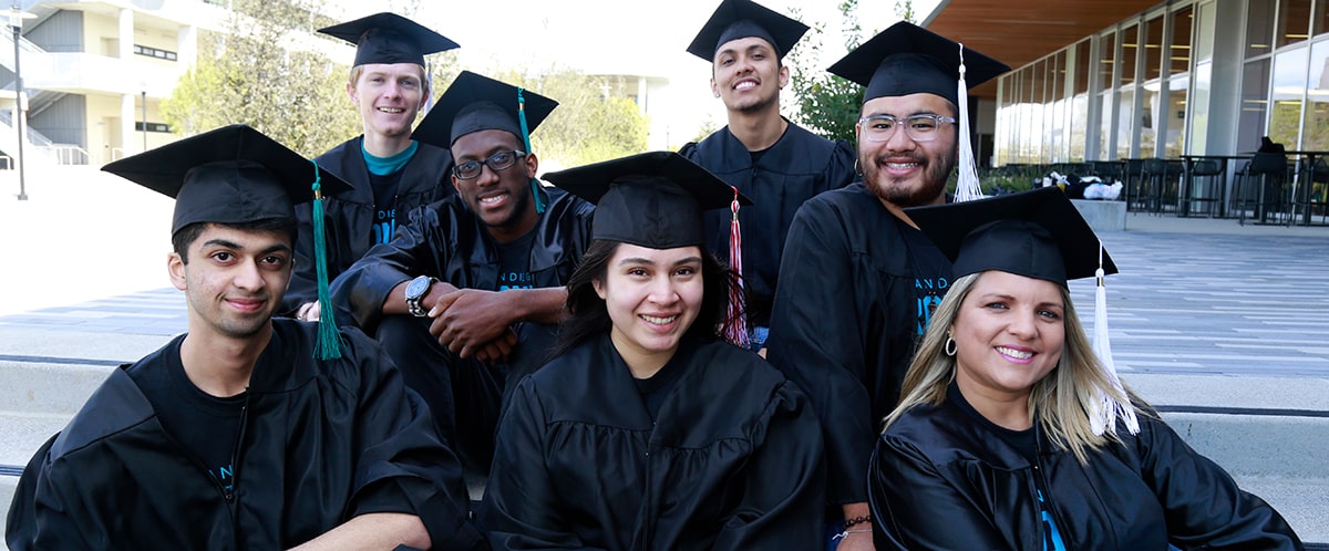 Seven students wearing caps and gowns