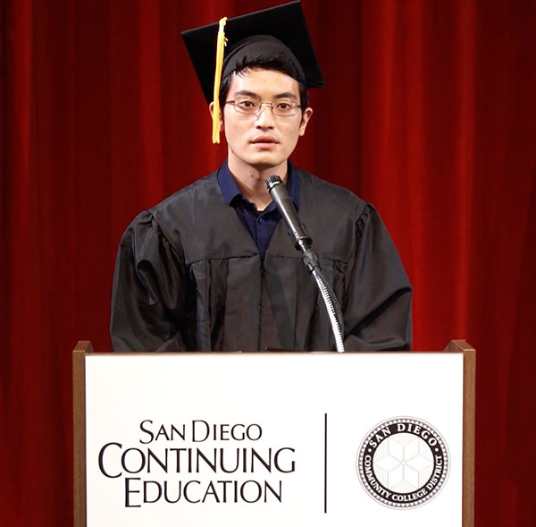 Brian Yamase in a graduation cap and gown