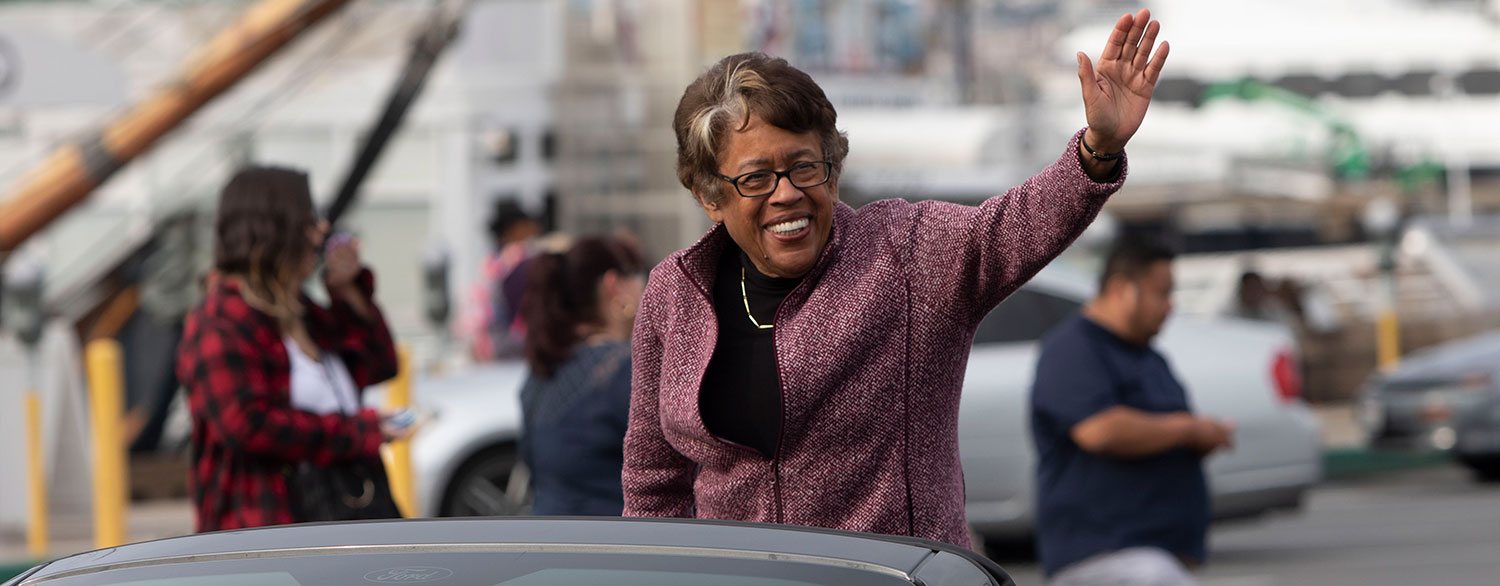 Constance Carroll waves from a car at a parade