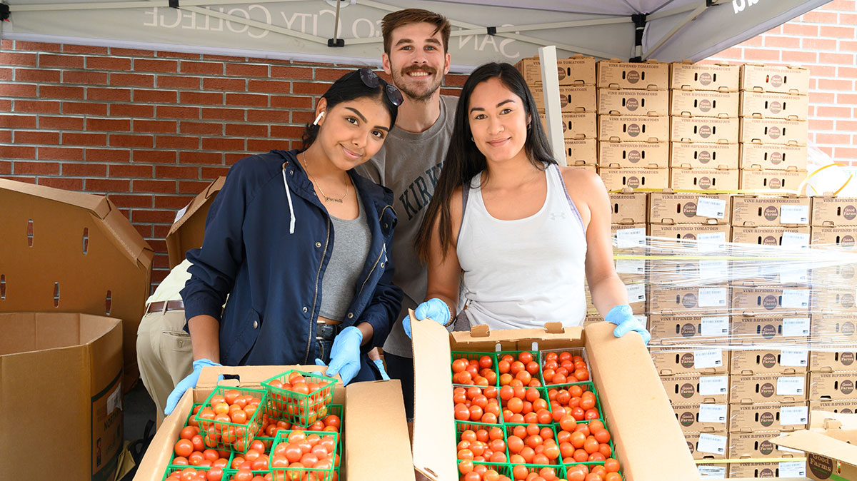 Volunteers hand out food during City College's farmers market