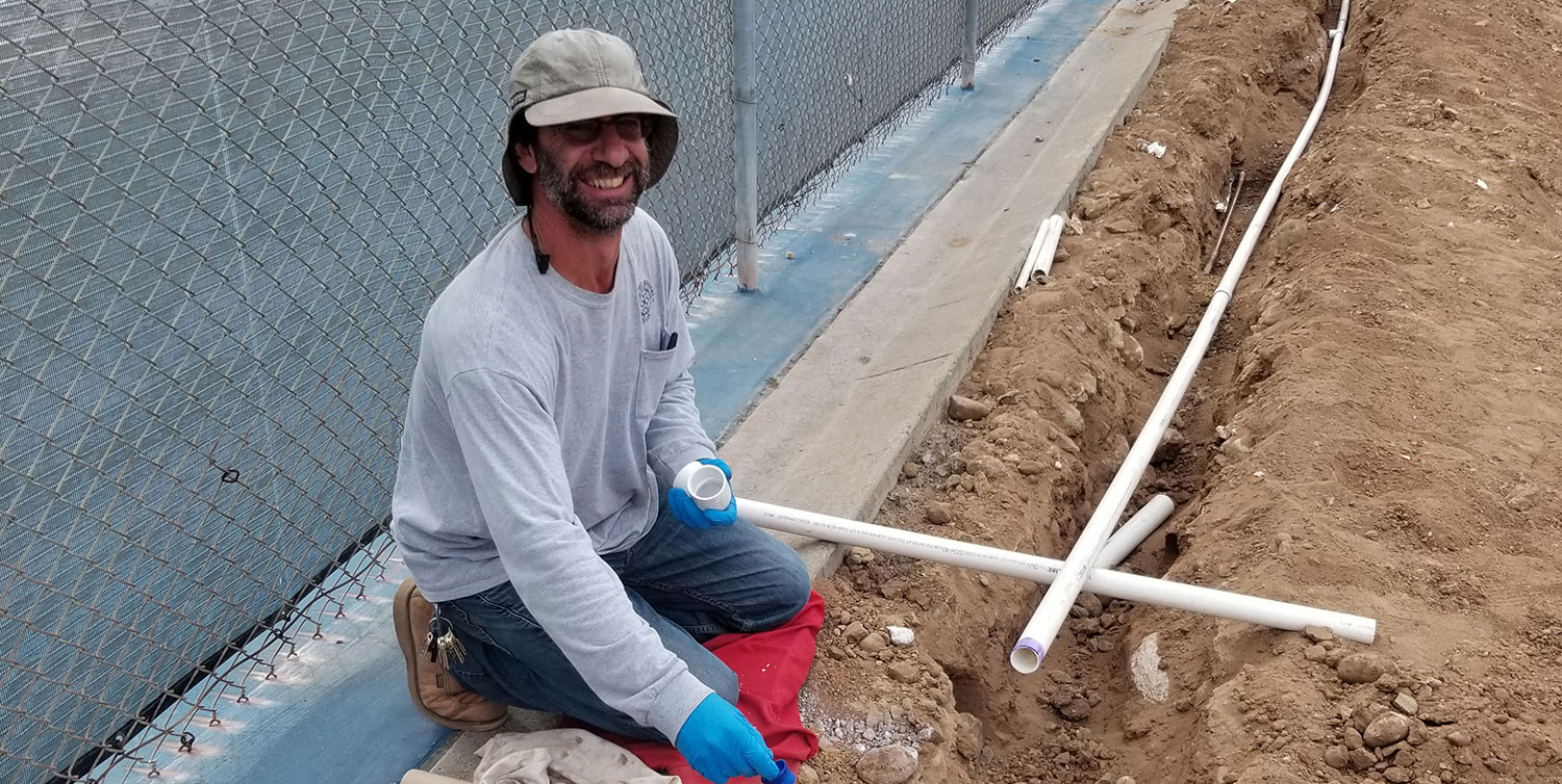 Irrigation technician Gerry Vanderpot works with pipes at mesa college