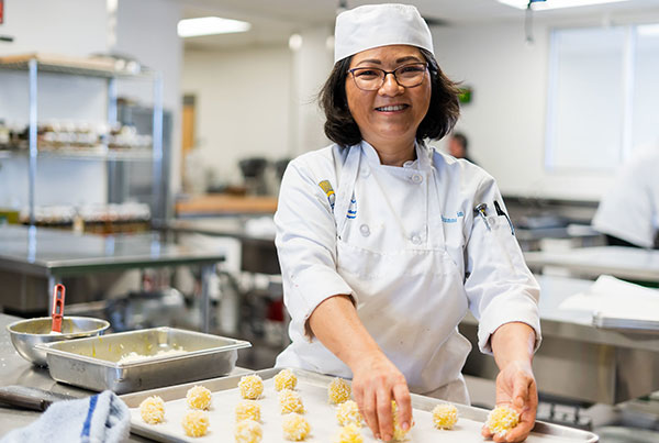 A culinary student works with dough in the kitchen