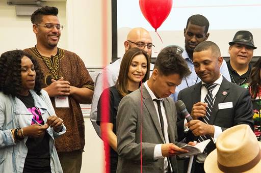 San Diego City College President Ricky Shabazz, right, surprises a student with a book and cash at the 2018 Fall HUBU Conference.