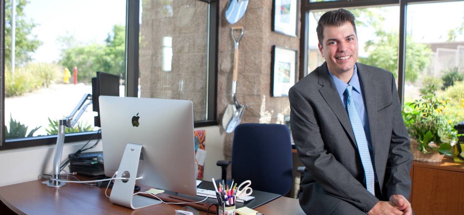 Dr. Cortez sits on a desk in an office