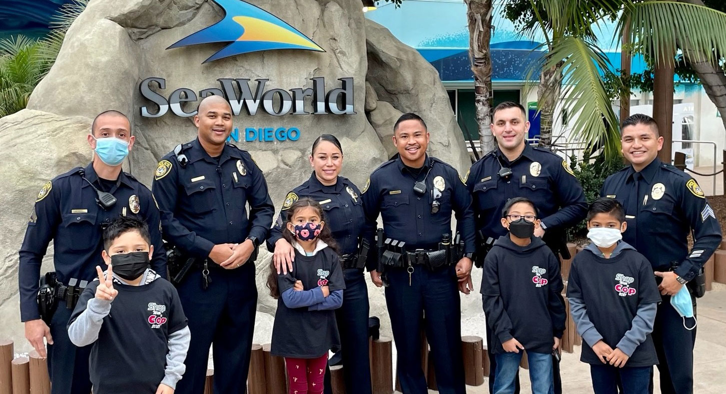Officers with students in front of a Sea World sign