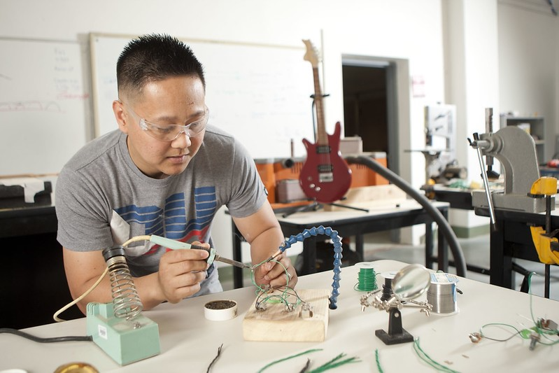 A student is soldering at a work station