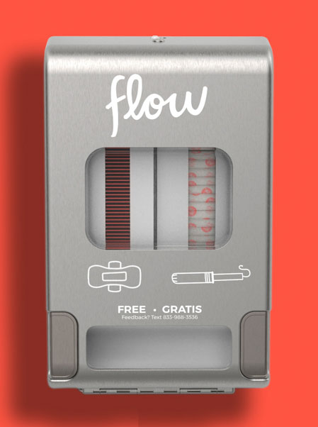 A gray dispenser that says Flow on it is hung on an orange wall. 