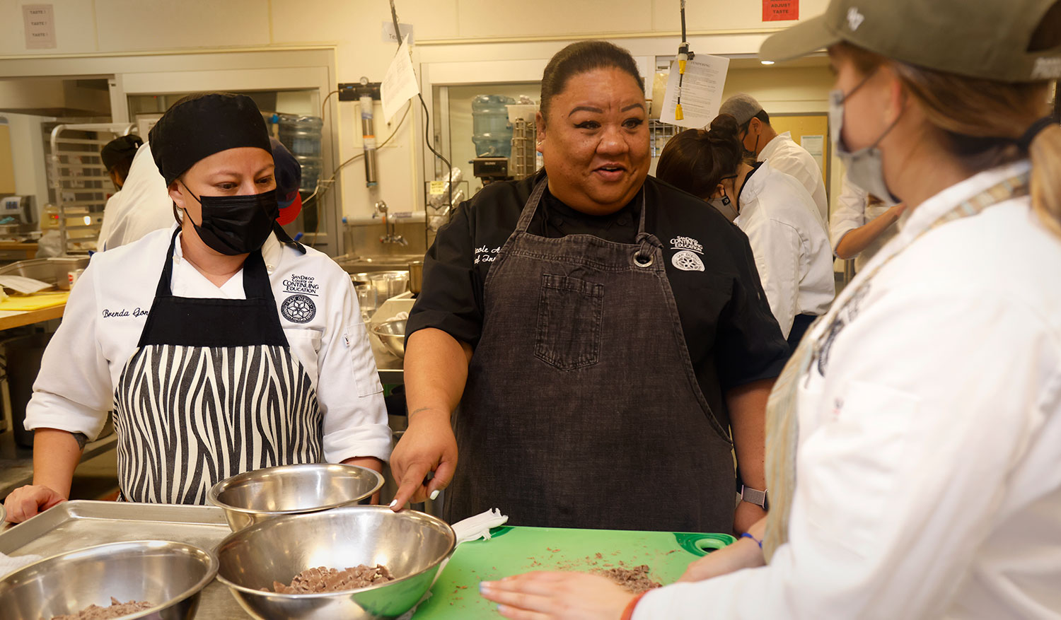 Nicole Austria with two students in a culinary class.