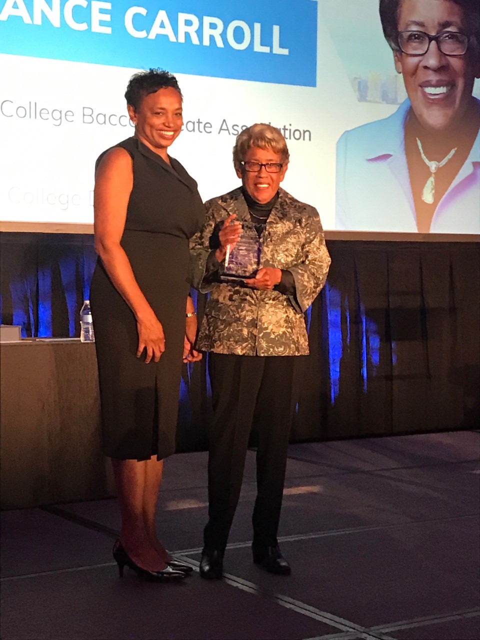 Dr. Constance M. Carroll, right, on stage with her award