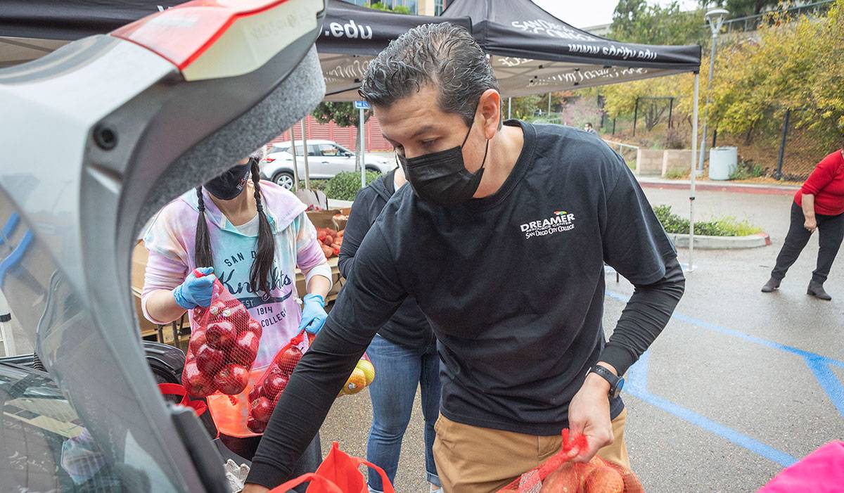 Adan Sanchez An employee loads food into the trunk of a car