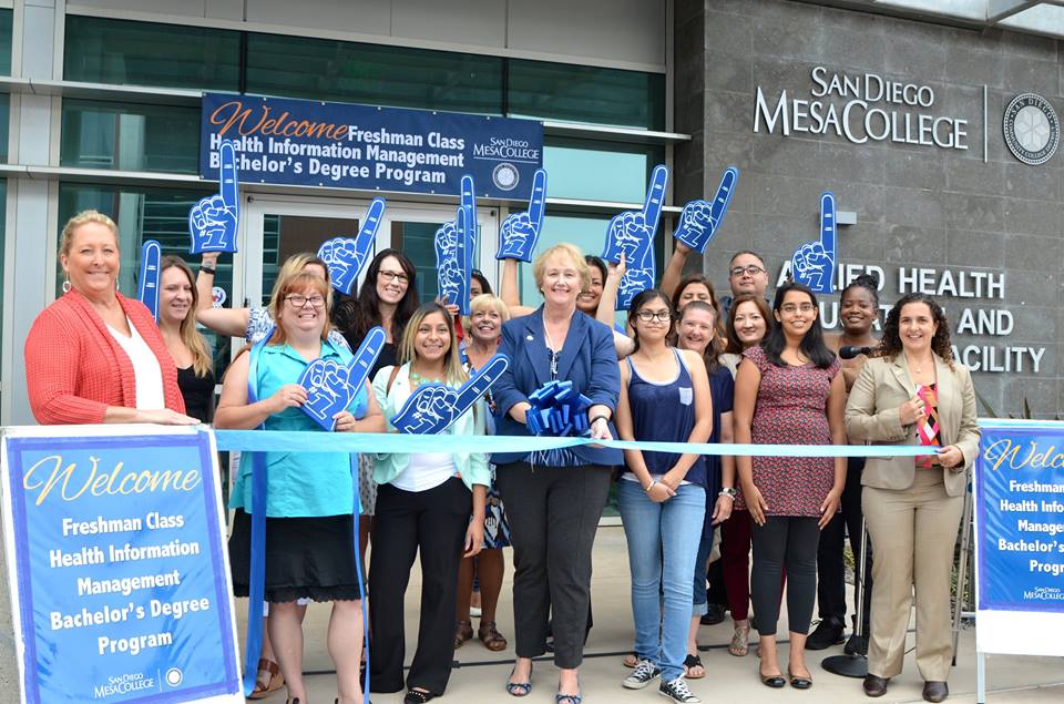 Pam Luster cuts the ribbon for the HIM baccalaureate program.