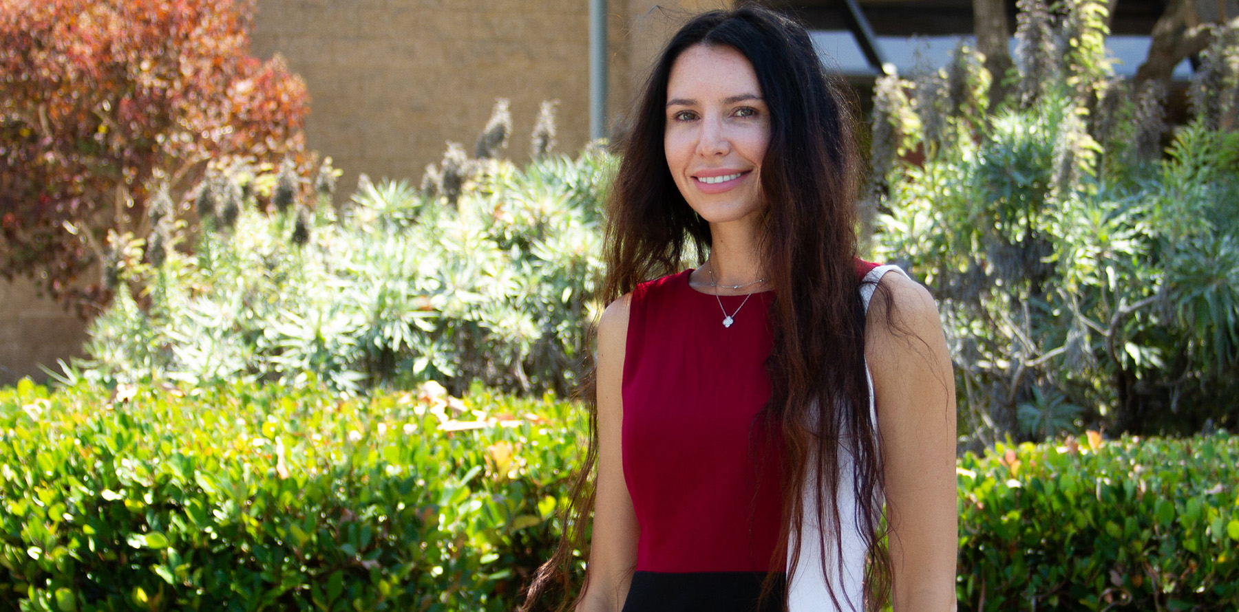 Julia Kogen stands by greenery outside of the Educational Cultural Complex