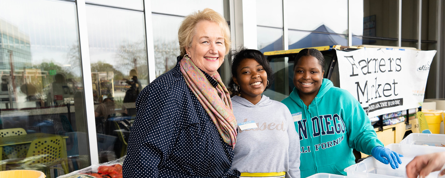 Pam Luster and students distribute food during a farmers market event in 2019.