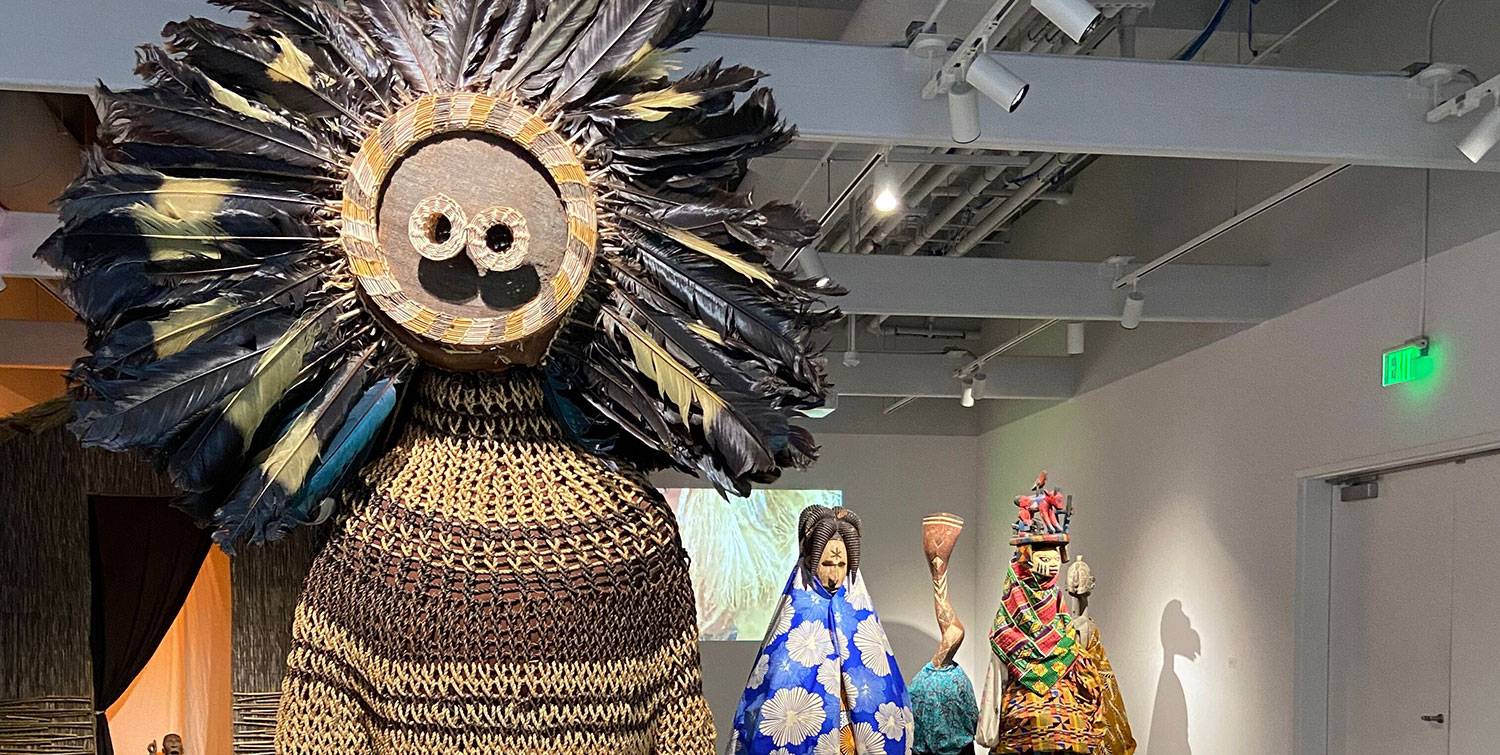 Several life-size dolls are on display wearing various traditional African types of dress