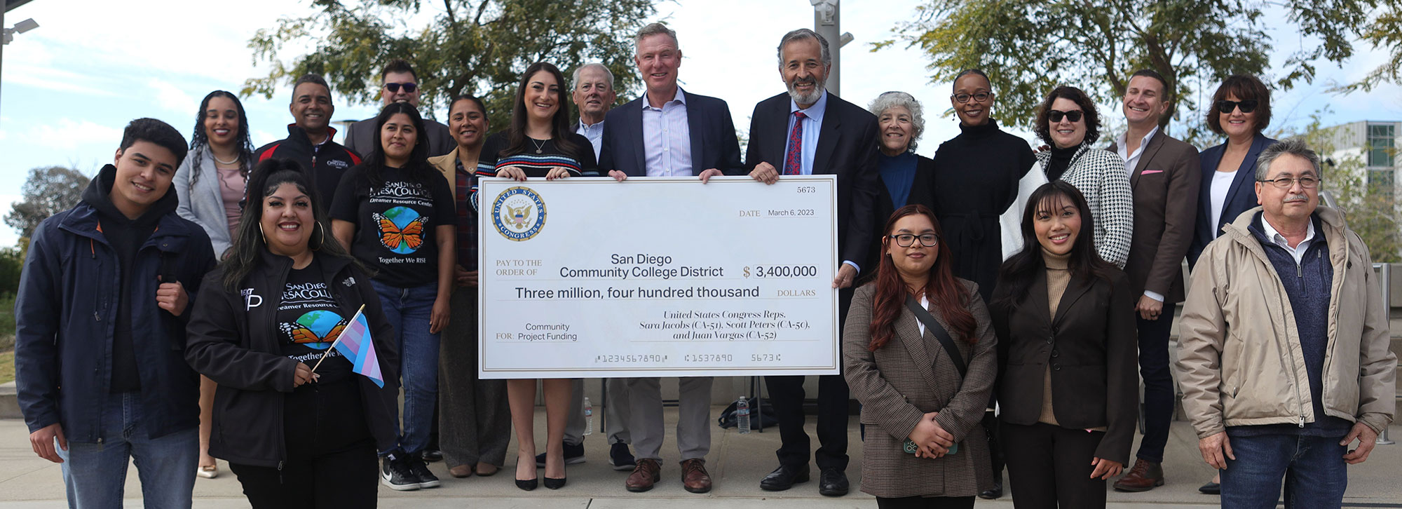 A group photo with the representatives, district officials and students with a giant check for 3.4 million dollars