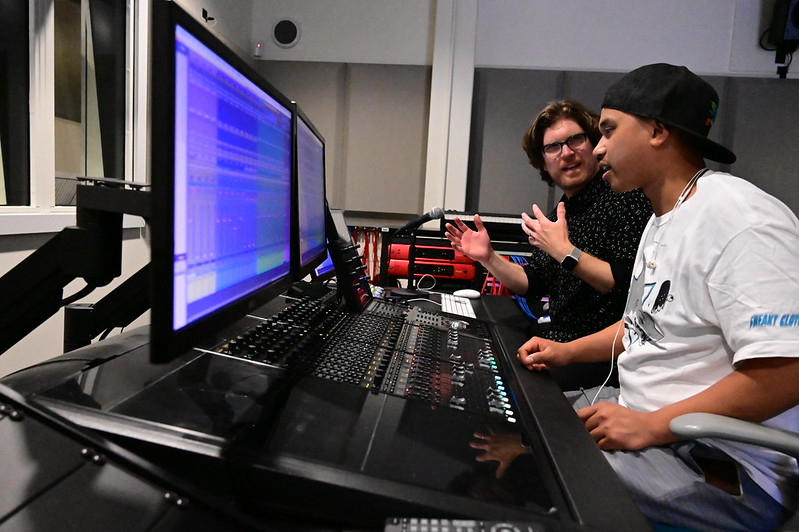 Mike Espar works with a student at the mixing board in the City College Recording Studio.