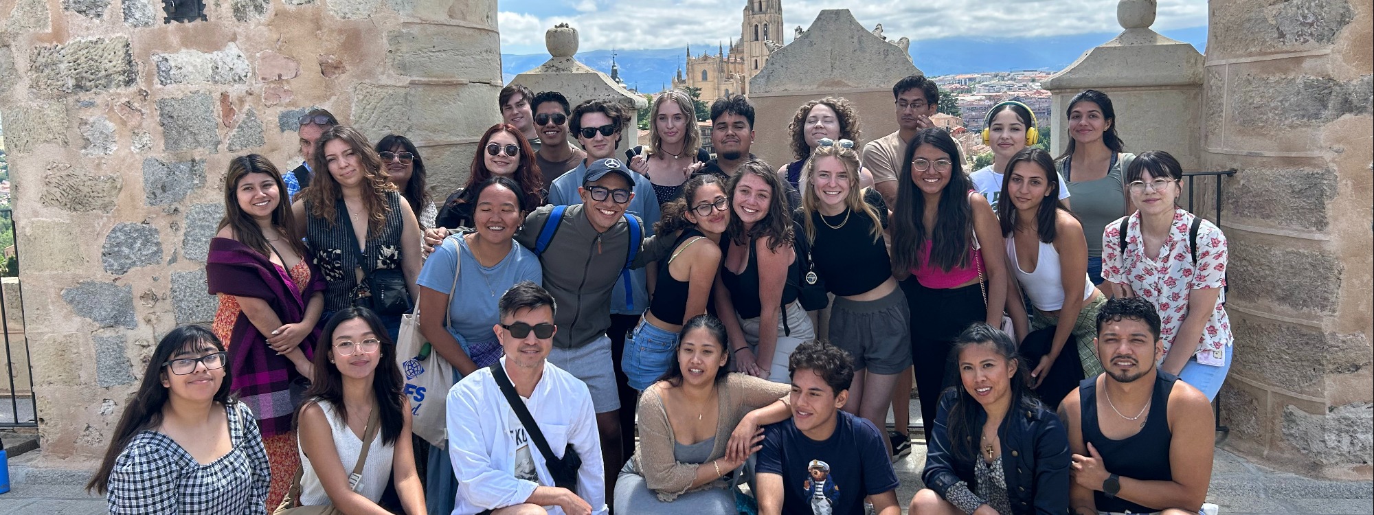 30 students pose for a group photo with Madrid in the background