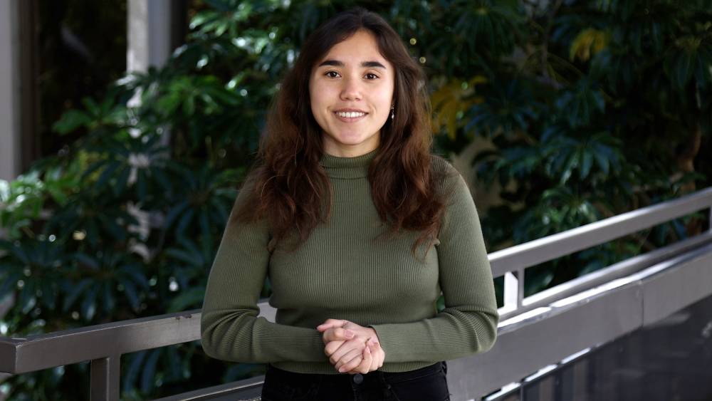A female student wearing a green shirt explains the new student email
