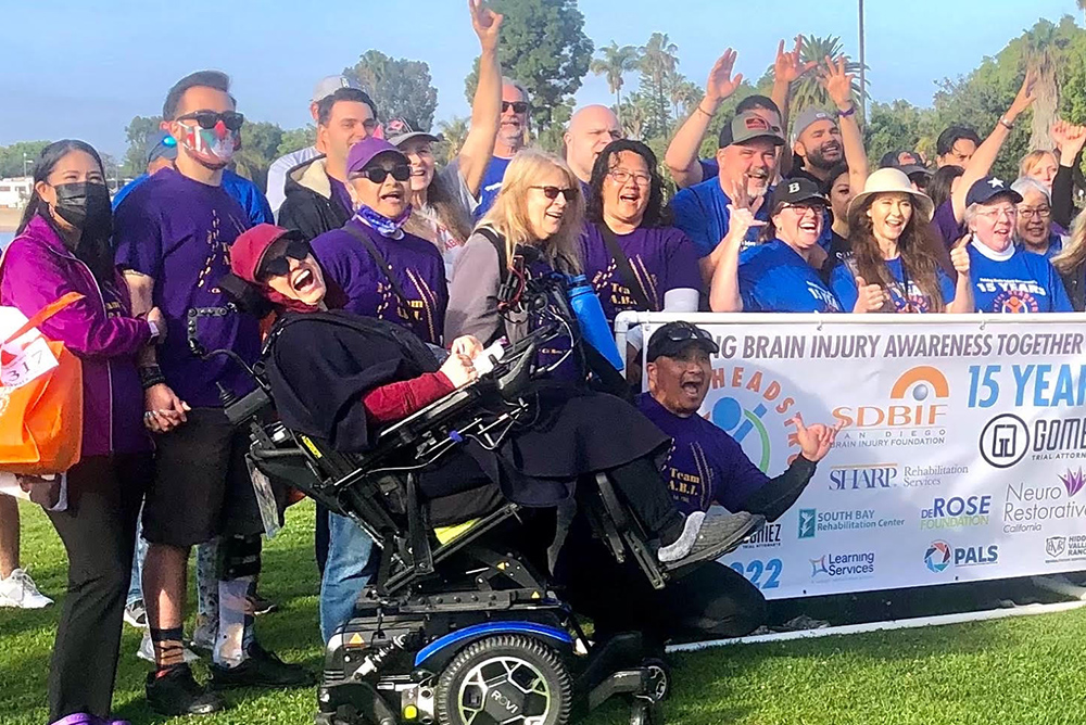 Team ABI takes a group photo on the grass in front of a team banner