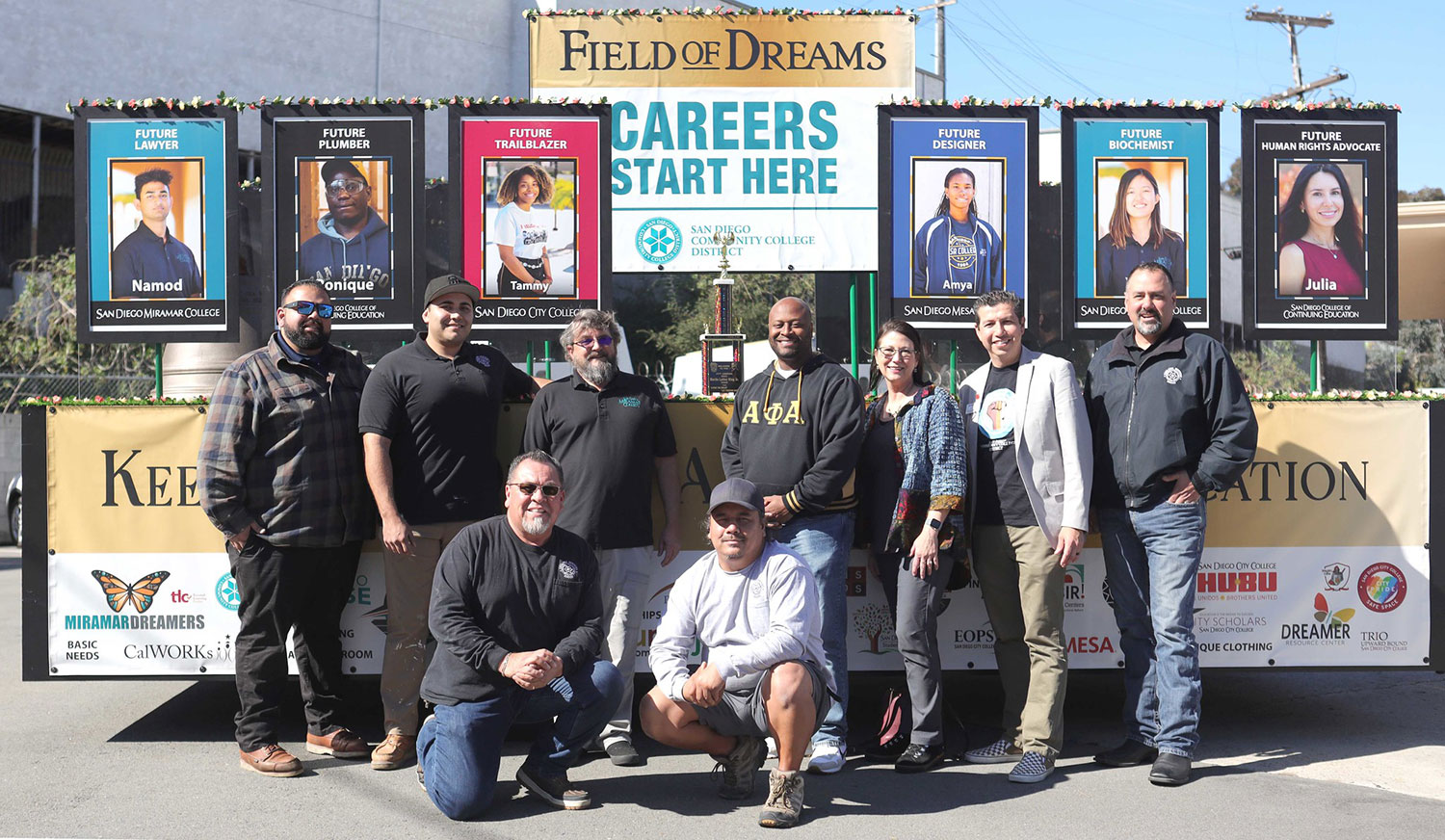 Nine people who worked on the construction of the float take a group photo in front of the district's MLK Float. The second place trophy is on the float.