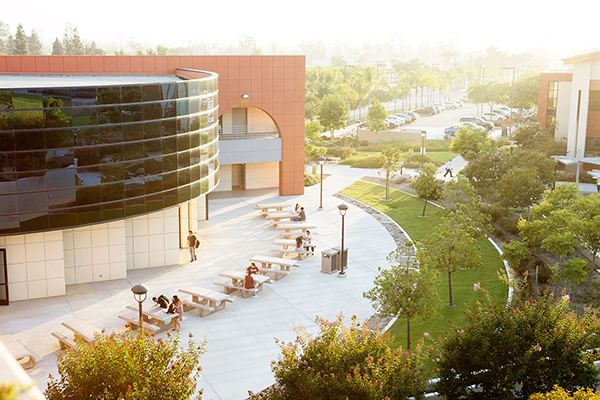 An outdoor college courtyard with tables and benches